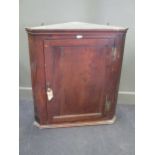 An 18th century oak splay front hanging corner cupboard