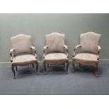 A set of three taupe suede and brass buttoned open armchairs, 107 high, 68 cm wide