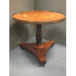 A rosewood and inlaid circular tilt top table, with a central circular image of a world map, with
