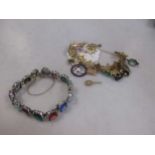 A filigree charm bracelet testing to at least 14ct and supporting a number of charms, 28.5g together