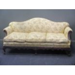 A carved frame camel back sofa, early 20th century, re-upholstered, c.197cm wide