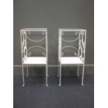 A pair of wrought iron white painted tables with glass tops