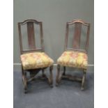 A pair of 18th century chairs, the stuffed over seats on scrolled legs