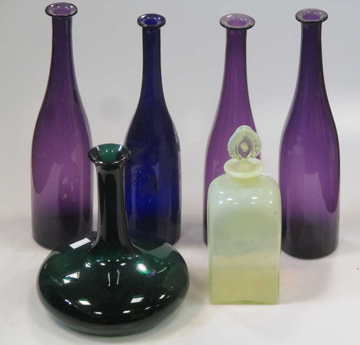 Three amethyst glass carafes, another blue glass example with etched decoration and others