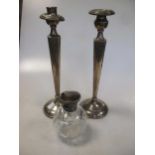 A pair of candlesticks marked 'sterling' (some damage), and a silver capped dressing table jar