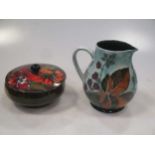 A Moorcroft flambé Hibiscus pattern drinking pot and a Moorcroft bramble pattern jug (2)