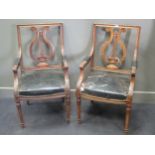 A pair of leather upholstered lyre back elbow chairs