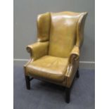 A George III style leather library armchair with brass stud decoration