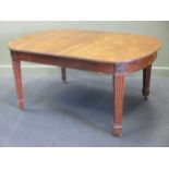 A late Victorian mahogany extending dining table with two leaves by James Shoolbred & Co,