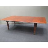 A mahogany extending dining table with two additional leaves
