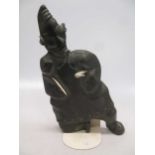 A 'Canada Eskimo Art' carved hardstone model of a hunter, with sticker to underside, on a stand,
