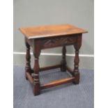 A carved oak joint stool on baluster turned legs joined by stretchers