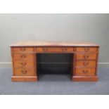 A mahogany pedestal desk in the Georgian style with leather lined top, fitted nine drawers on a