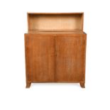 A Heal's limed oak cabinet with bookcase top,