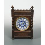 An Aesthetic Movement oak bracket clock in the manner of Lewis Foreman Day, circa 1880,