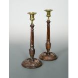 A pair of turned and carved columnar candlesticks,