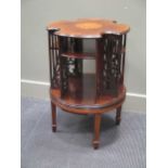 A 19th century inlaid mahogany revolving bookshelf of circular form with fret work recesses on spade