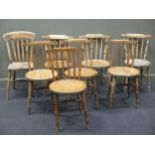 A set of four 19th century pine kitchen dining chairs with stick backs and circular seats,