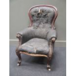 A Victorian mahogany spoon back arm chair, with scrolled arms and carved cabriole legs, the button