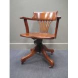 An Edwardian oak revolving desk chair