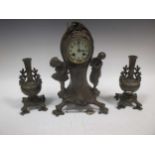 An Art Nouveau style three piece clock garniture, comprising of a figural mantel clock and a pair of