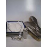 A silver pendant and necklace: a silver sifter spoon, and a dressing table set