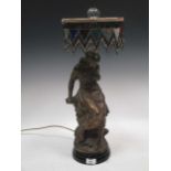 After Auguste Moreau, a bronzed spelter figural table lamp with bead work shade