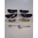 A matched set of four silver salts with blue glass liners and spoons