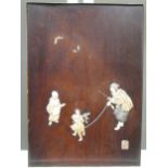 A Japanese wooden panel inlaid with ivory and mother of pearl depicting a boy watching a dancing