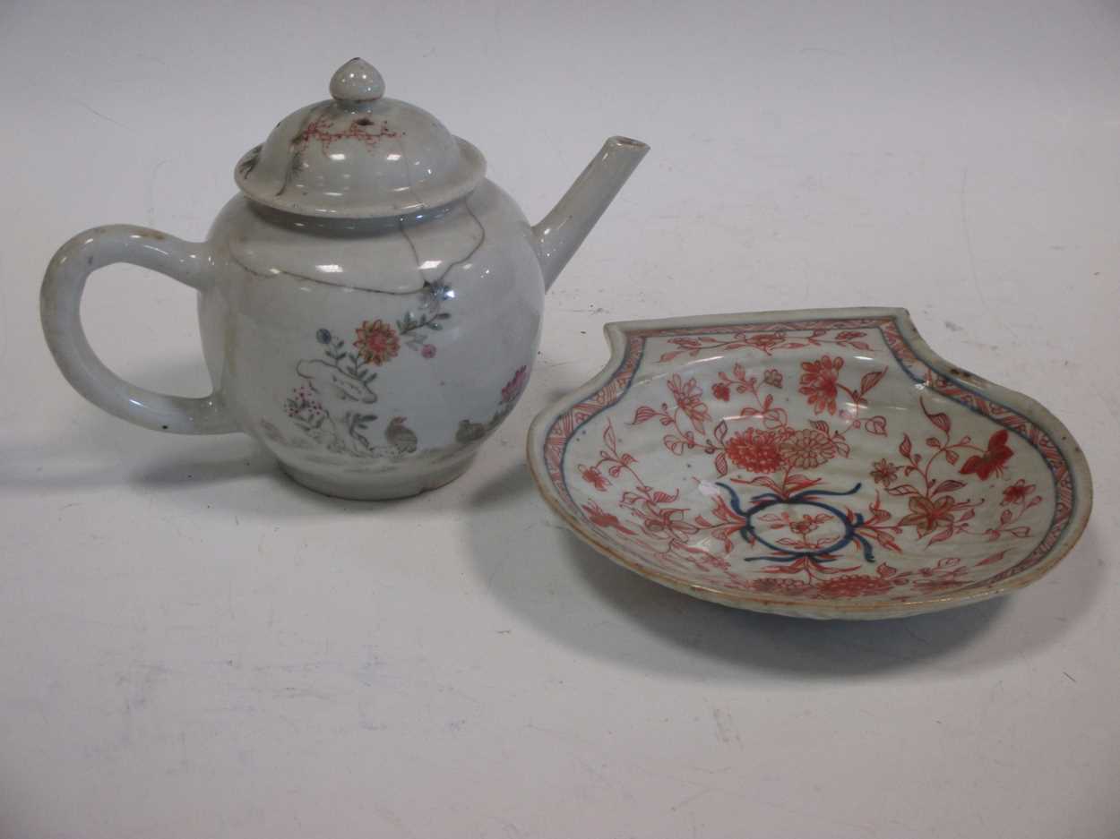 A small Chinese teapot and a small shell shaped dish