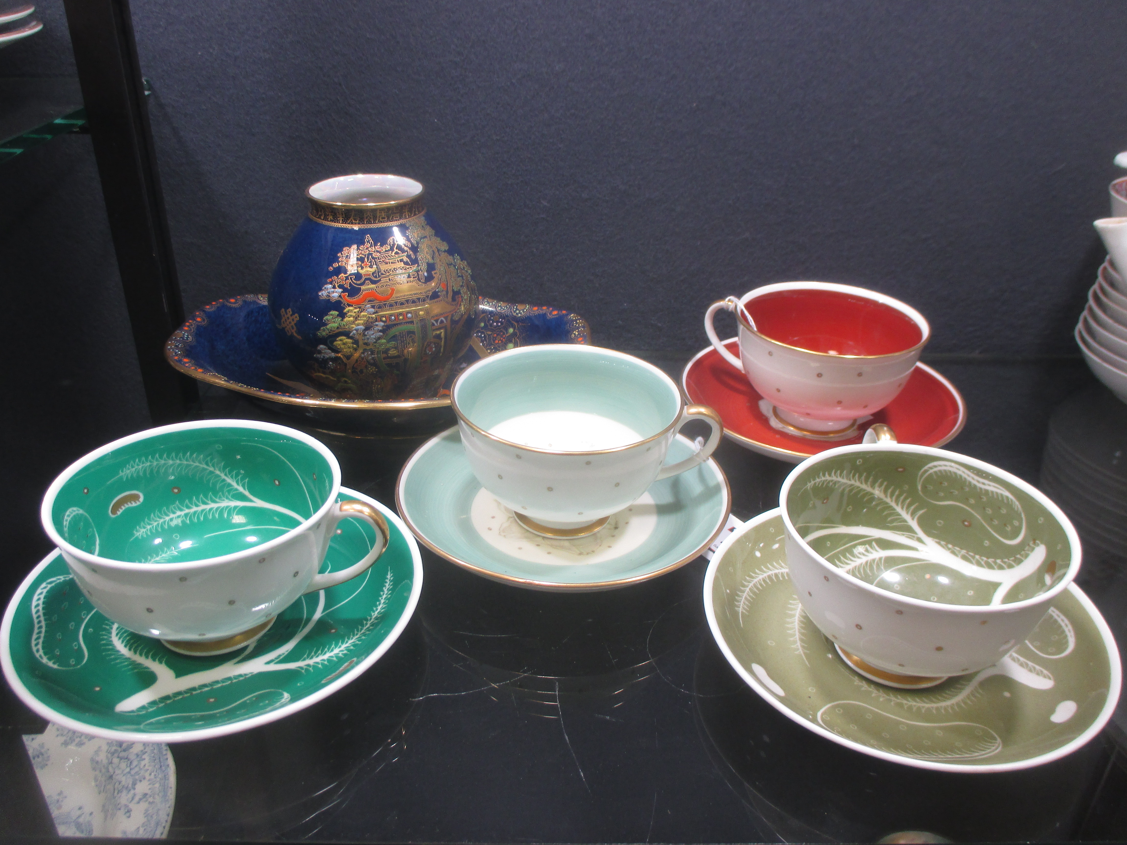 Four Susie Cooper tea cups and saucers, a Carlton ware vase and dish