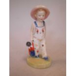 A Royal Doulton figure of a boy holding a Golly, 13cm high