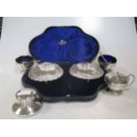 A carved pair of silver scallop shaped butter dishes and other small silver