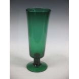 A large green glass vase of flared cylindrical form raised on a spreading circular foot, 38cm high