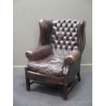 A George III style leather wing back armchair