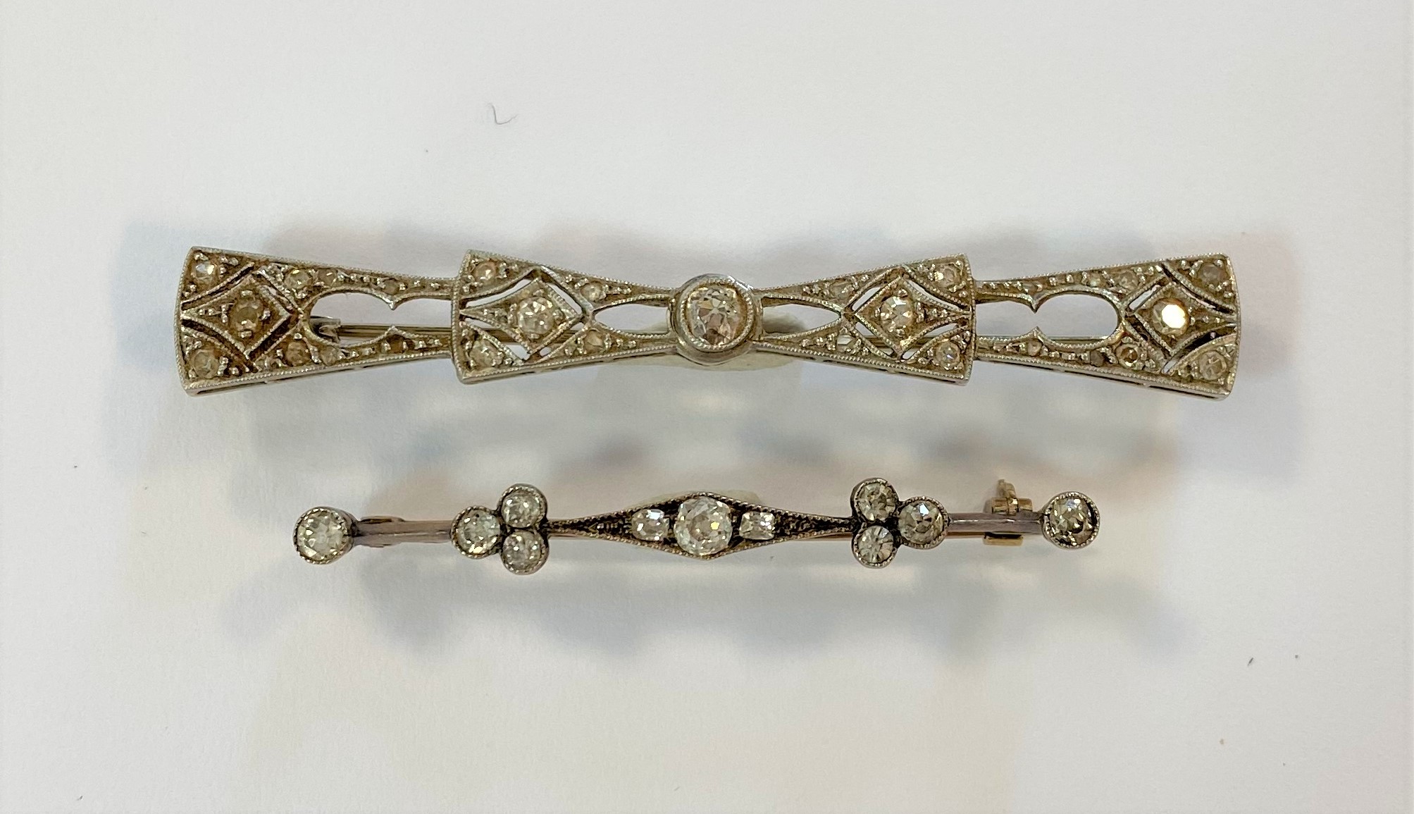 Two diamond set bar brooches,