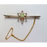 A bar brooch set with an opal and diamonds,