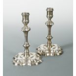 Two almost matching George II cast silver candlesticks,