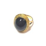 A dress ring set with a cabochon garnet,