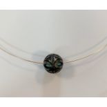 A carved Tahitian cultured pearl pendant with turquoise bead interior and wire,