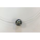 A carved Tahitian cultured pearl pendant with turquoise bead interior and wire,