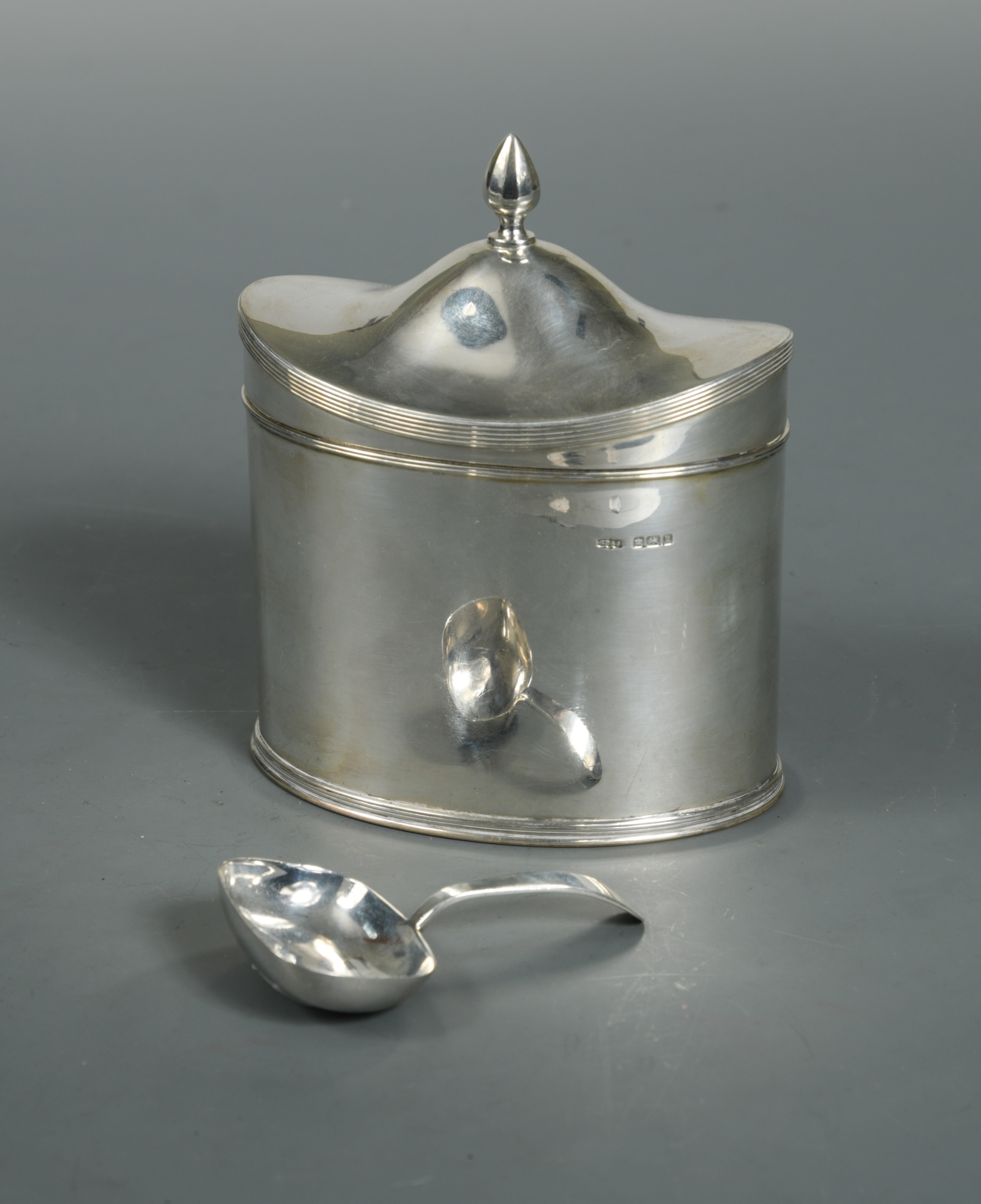 A George V silver tea caddy and caddy spoon,