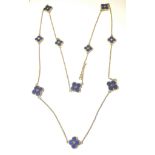 A chain necklace of lapis lazuli set quatrefoil flowers,
