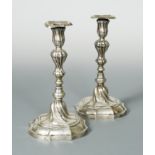 A pair of German metalwares cast candlesticks, and another pair,
