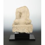 A Chinese grey stone seated Buddhist deity, headless, perhaps Wei Dynasty,