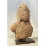 An Indian carved pink sandstone fragmentary head and upper torso of Shiva,