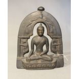 A Nepalese black polished stone seated Buddha with arched aureole, probably 20th century,