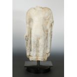 A Chinese pale grey limestone fragmentary torso of a standing Buddha, in Qi Dynasty style,