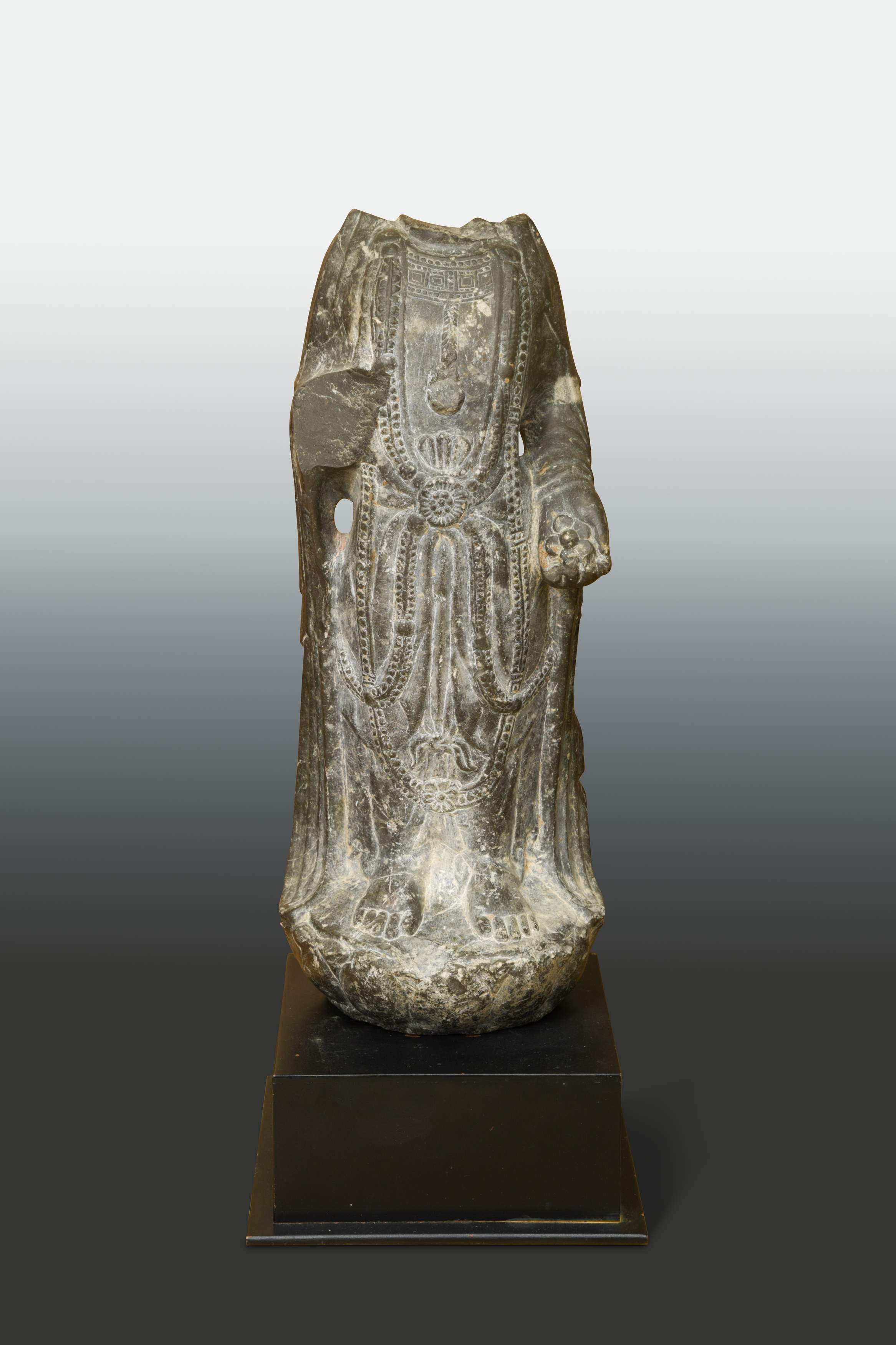 A dark limestone torso of a Bodhisattva, perhaps Northern Qi Dynasty (550 AD - 577 AD),