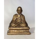A Tibetan gilt bronze seated Monk, 19th century or possibly earlier,